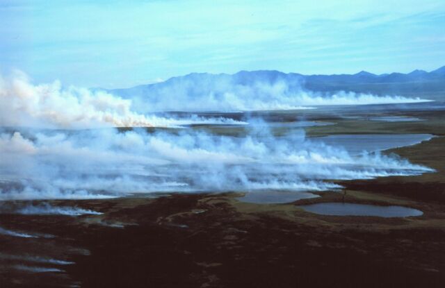 White smoke rising from the tundra in front of the Baird Mountains.