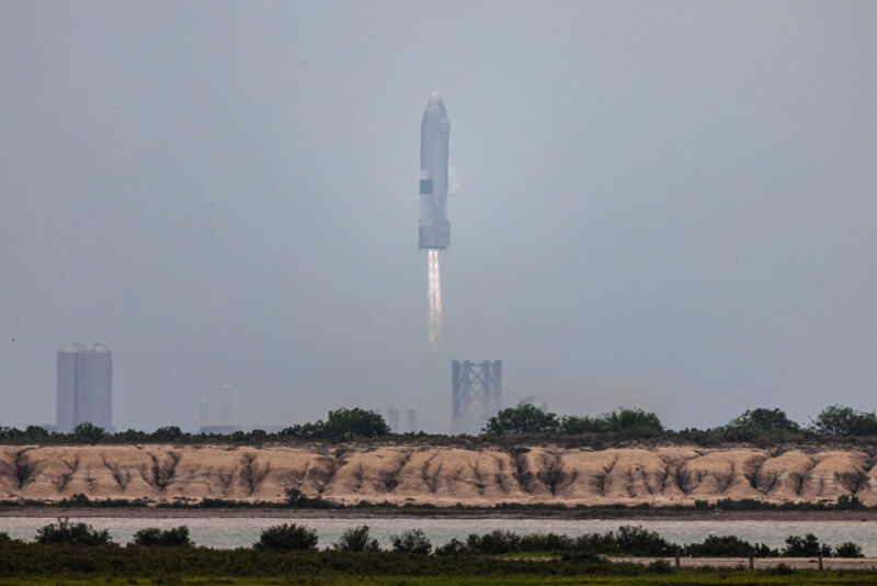 Image of a rocket with engines firing just above its landing pad.