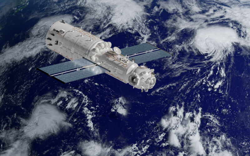 Image of a space craft with solar panels with the earth in the background.