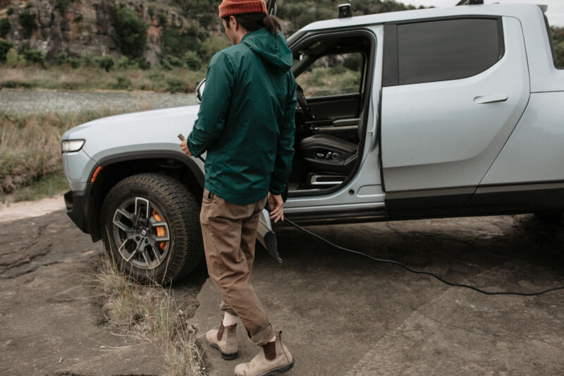 A man carries an air hose to a truck tire