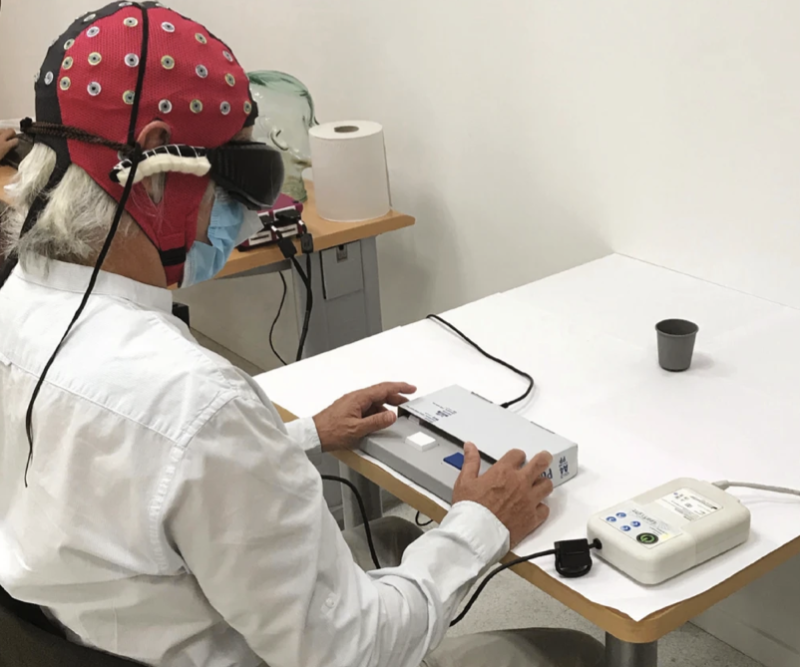 Image of a seated person wearing a red cap and goggles.