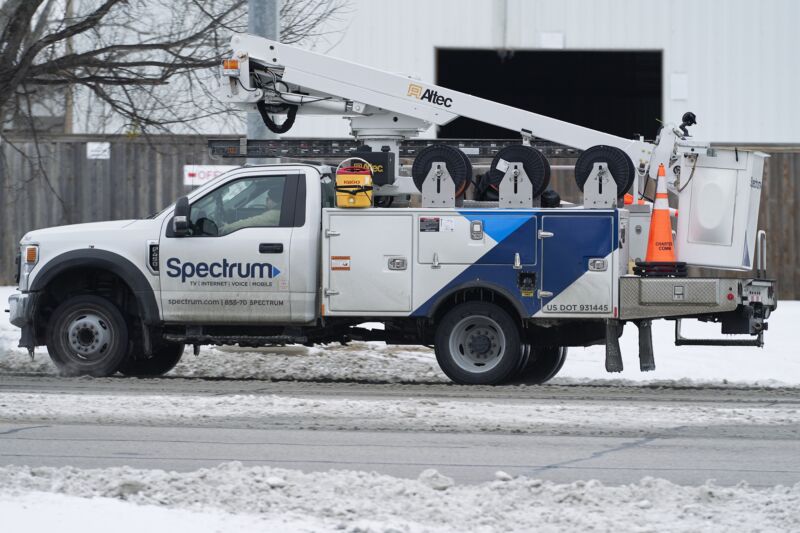 Un camión de servicio Charter Spectrum en una calle nevada.