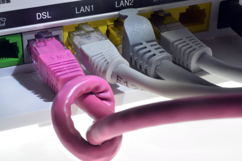 An Internet cable tied into a knot and plugged into a router's DSL port.