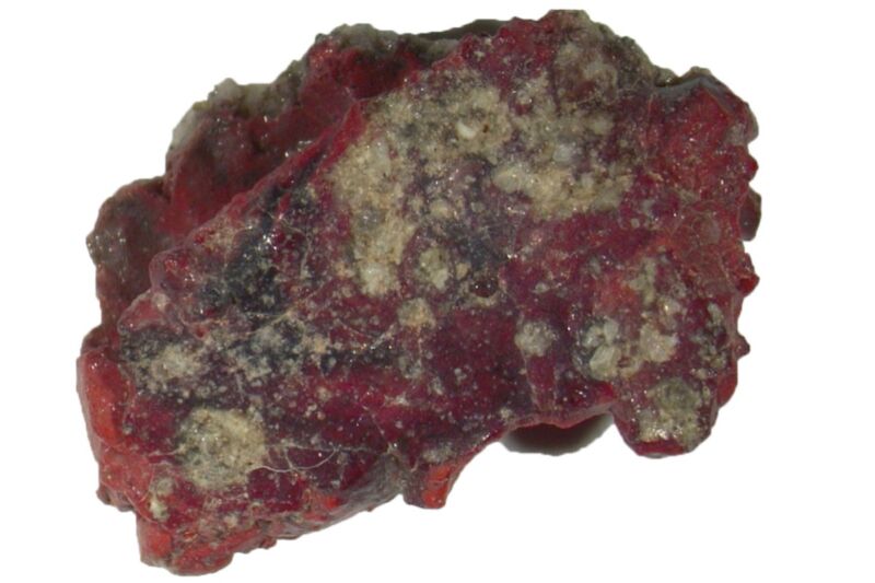 A shiny red rock against a white background.