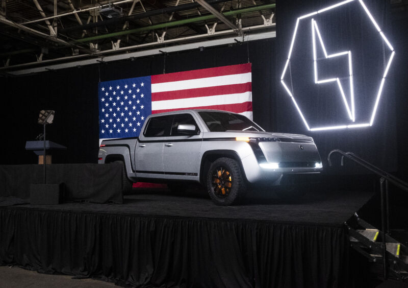 A silver Lordstown Endurance truck on stage with a big American flag