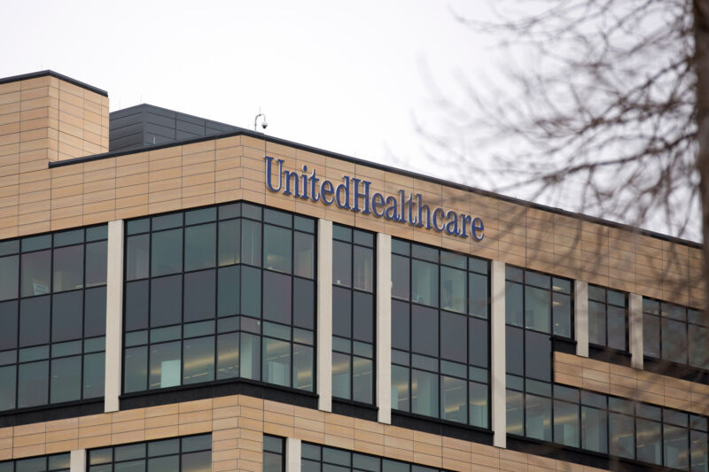 Edificio de varios pisos de vidrio y ladrillo con el logotipo de UnitedHealthcare en el exterior.