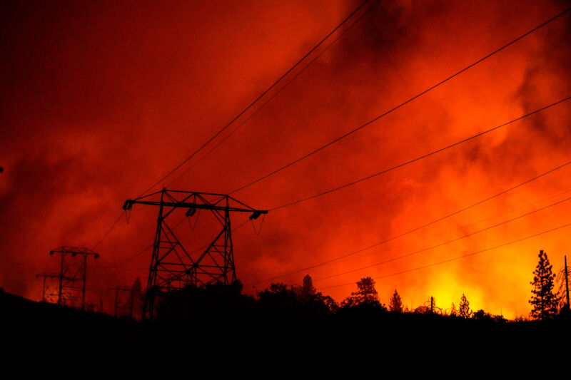 Liniile electrice sunt turnate în siluetă în timp ce Creek Fire se strecoară în comunitatea Shaver Springs, lângă Tollhouse Road, marți, 8 septembrie 2020, în Auberry, California.