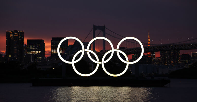 A barge carrying the Olympic Rings crosses Tokyo Bay.
