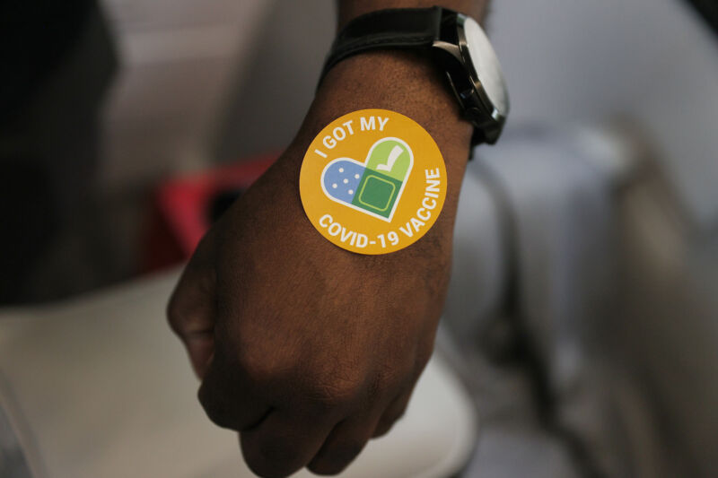 A person gets a sticker after getting a Pfizer-BioNTech COVID-19 vaccine.