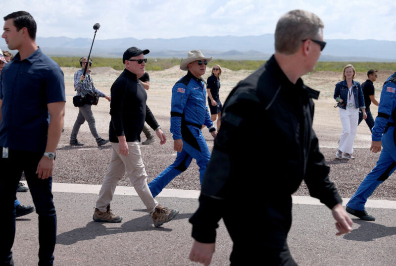 Blue Origin CEO Bob Smith (black hat) walks with Jeff Bezos after his flight on Blue Origin’s New Shepard into space.