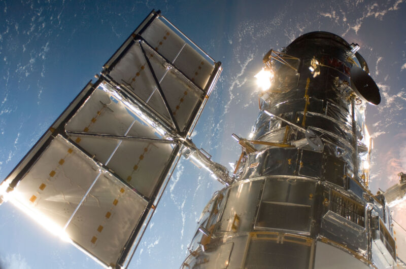 Image of the Hubble Space Telescope with Earth as a backdrop.