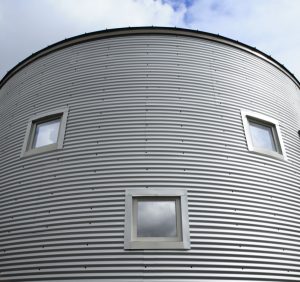 Window pattern on corrugated metal building resembles a face.