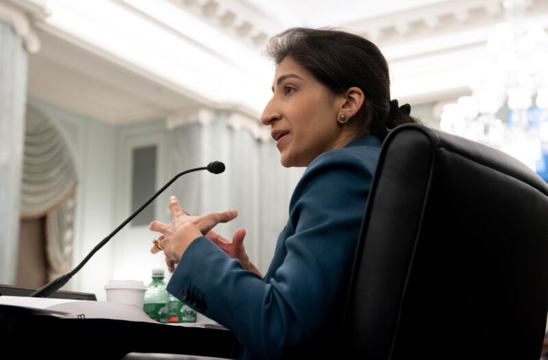 Lina Khan speaking and gesturing with her hands at a Senate committee hearing.