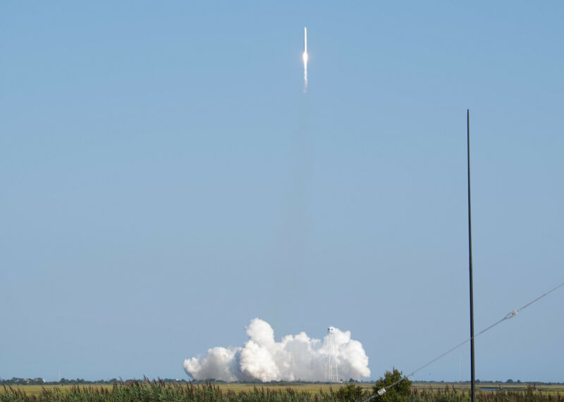 Un cohete deja una nube de humo cuando lo lanza a un cielo azul.