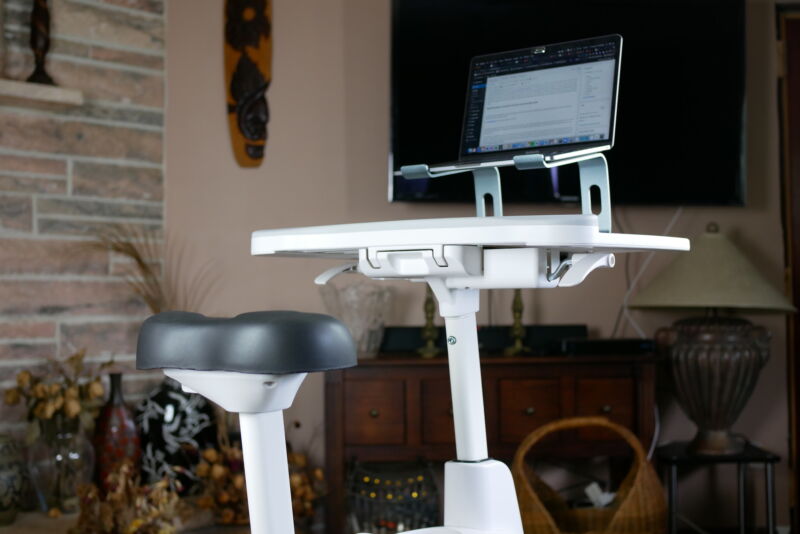 the bicycle seat and desktop of the desk bicycle with a laptop and wireless keyboard on it