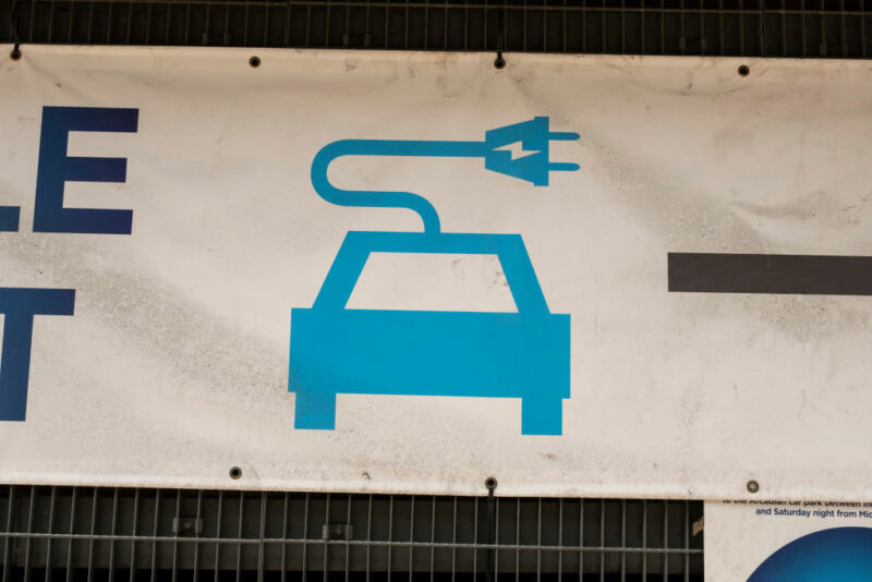 Outdoor signage advertises an electric vehicle charging station.