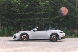 A white 911 Targa 4 GTS parked with the roof down.