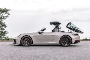 A white Porsche 911 Targa 4 GTS shown midway through raising its roof.