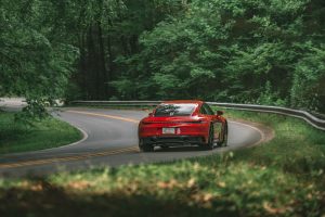 A red Porsche 911 Carrera GTS on a twisty road