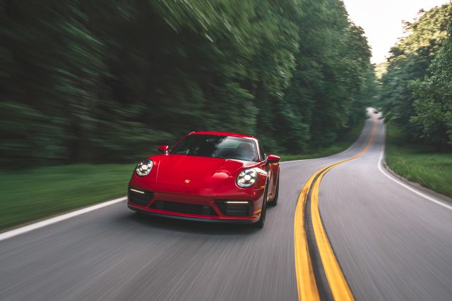 A red Porsche 911 Carrera GTS on a twisty road