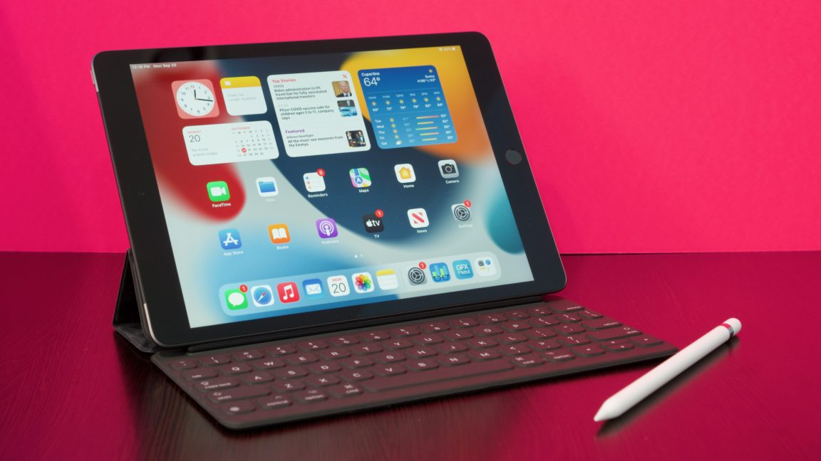 Ninth-generation Apple iPad resting in Smart Keyboard case with Apple Pencil sitting on the desk beside it.