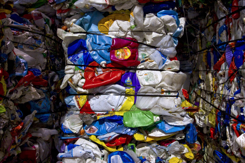 Discarded plastic bottles made of high-density polyethylene (HDPE) are bundled at a recycling center.