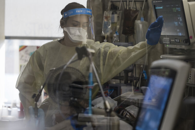 A healthcare worker treats a patient inside a negative pressure room in the Covid-19 intensive care unit at Freeman Hospital West in Joplin, Missouri, on Tuesday, Aug. 3, 2021.