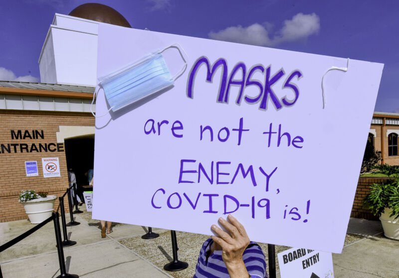 A protester holds a placard outside an emergency meeting of the Brevard County, Florida School Board in Viera to discuss whether face masks in local schools should be mandatory. 