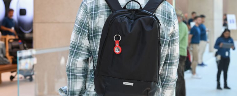 A plastic tag hangs from a young man's backpack.