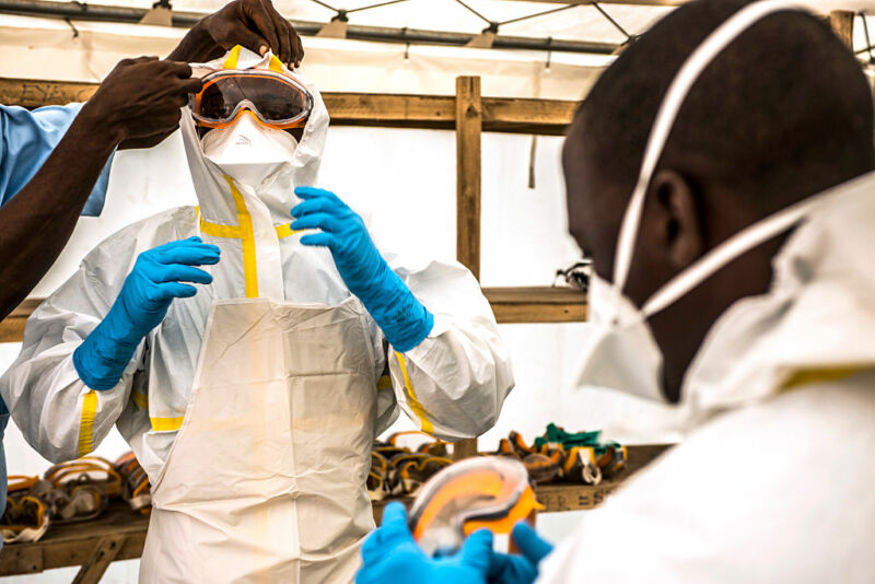 Image of two men in protective clothing and goggles.