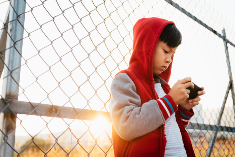 Uma criança usa um smartphone.