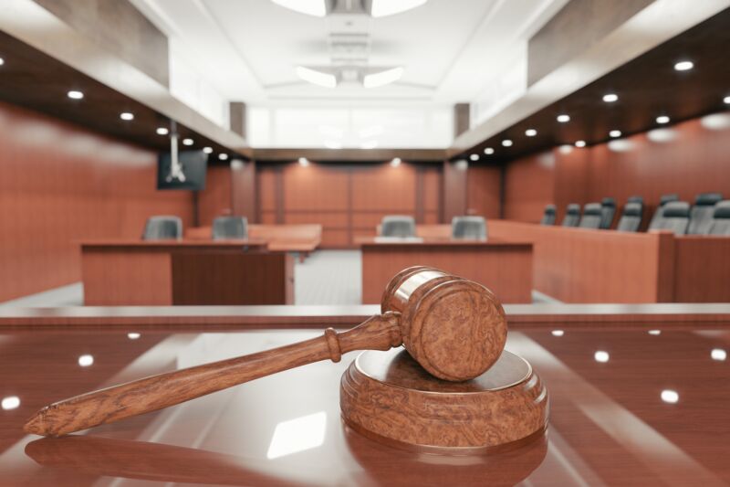 A gavel and jury box in an empty courtroom.