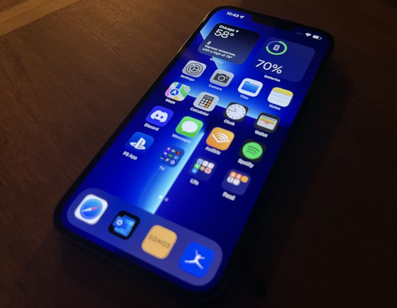 A large OLED screen on a desk in a dark room