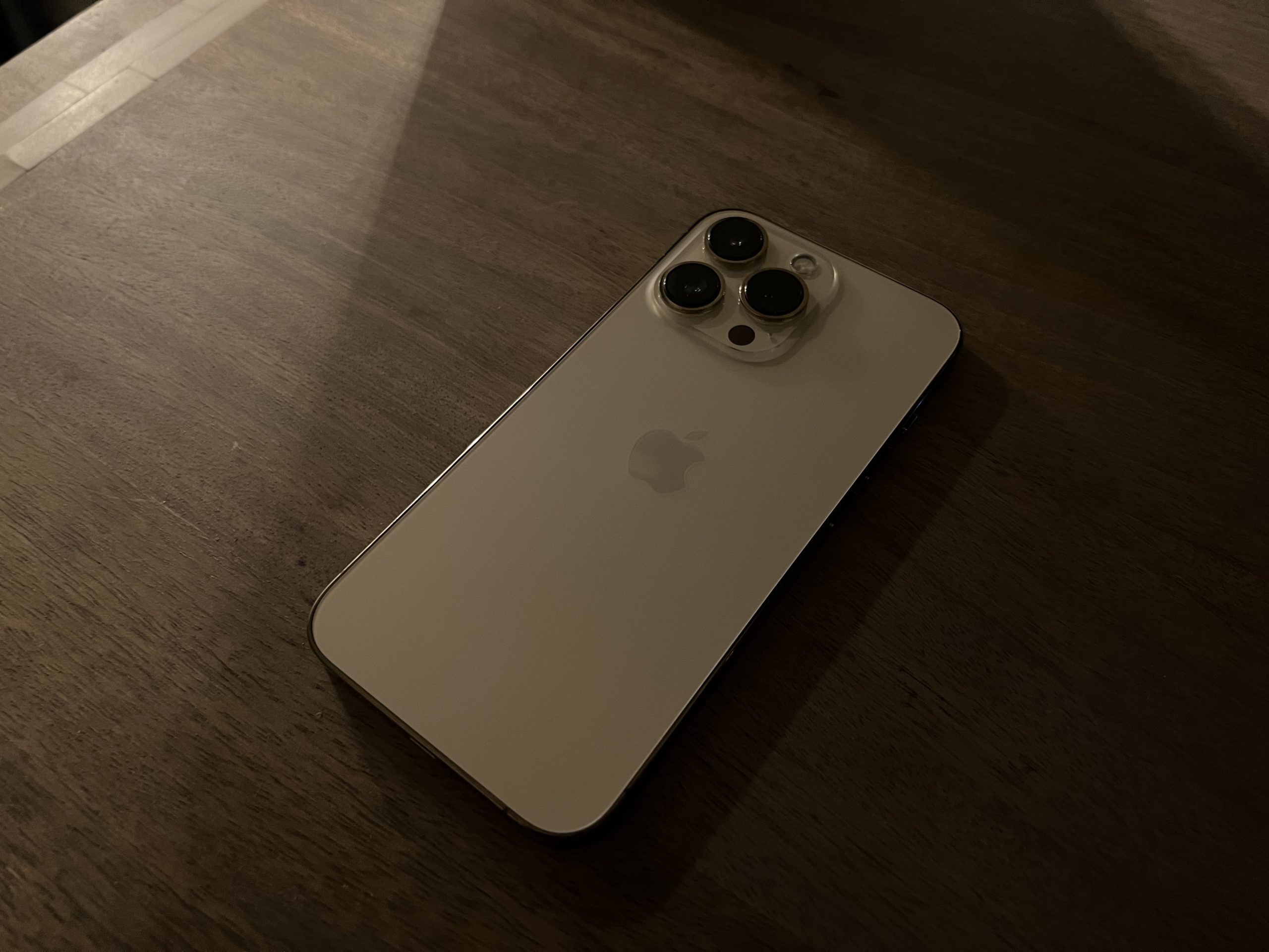 A gold-colored iPhone with three large camera lenses.