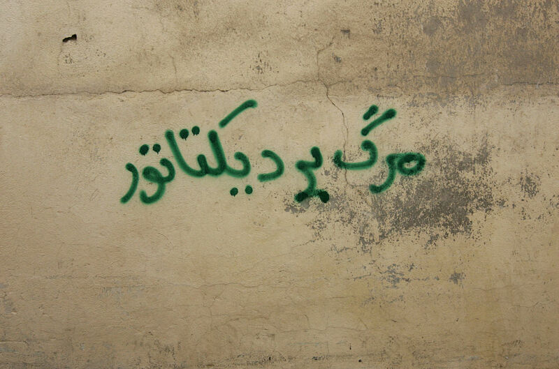 An antigovernment graffiti that reads in Farsi "Death to the dictator" is sprayed at a wall north of Tehran on September 30, 2009. 