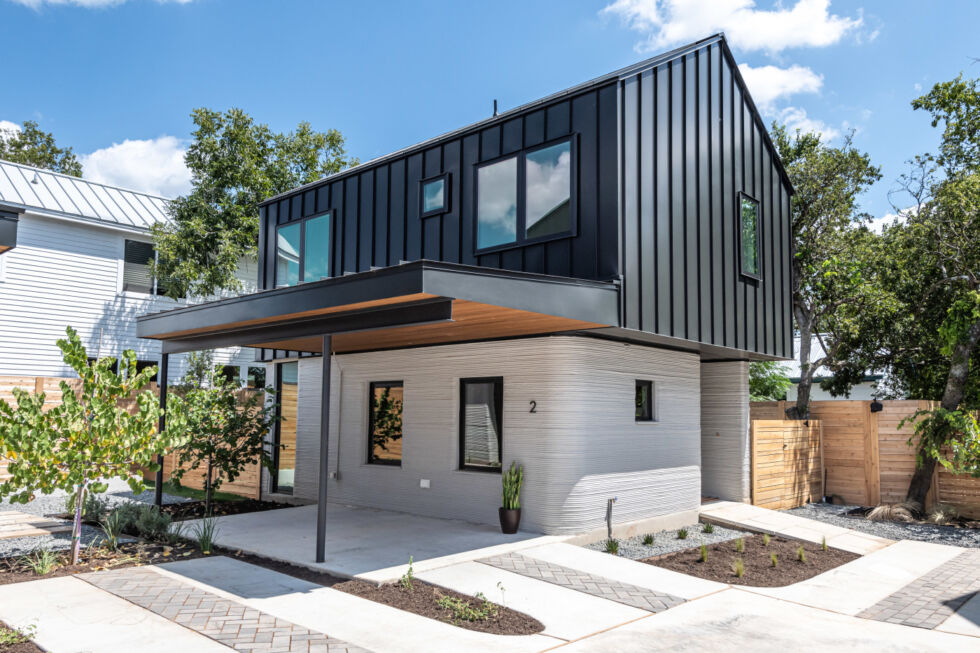 Icon heeft vier huizen gebouwd in Oost-Austin met behulp van zijn 3D-printtechnologie.  De muren van de eerste verdieping zijn gemaakt van bedrukt beton, terwijl de tweede verdieping en afwerkingen zijn voltooid met behulp van traditionele technieken.