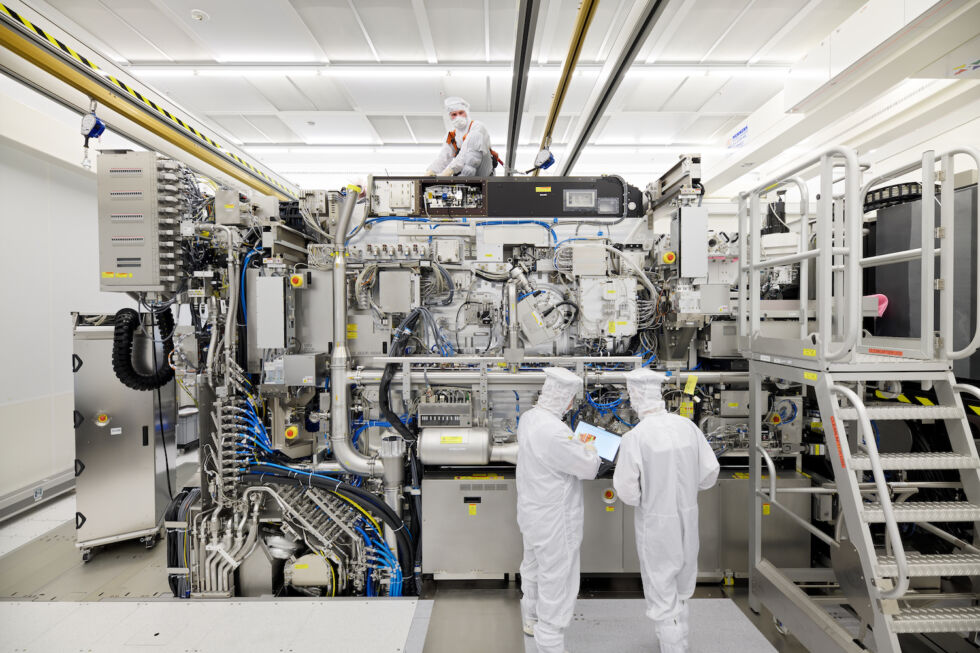 Technology Engineers perform final assembly on an extreme ultraviolet lithography machine in a clean room at ASML's headquarters in Veldhoven, Netherlands. 