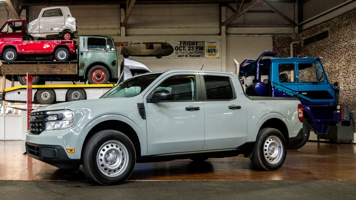 A Ford Maverick truck parked in front of big and small trucks at the Lane Motor Museum