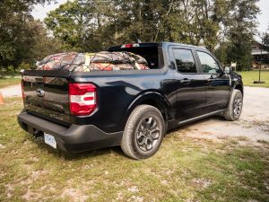 A black Ford Maverick with 1,000lbs of mulch bags in the bed