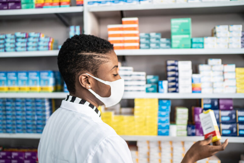 Image Of A Female Pharmacist Wearing A Face Mask.