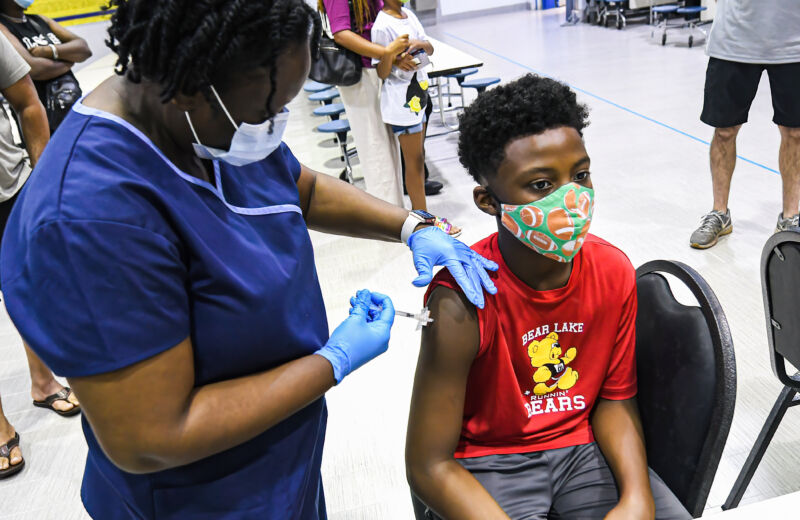 A nurse gives a boy a dose of the Pfizer vaccine at a COVID-19 vaccine clinic in Florida on the day before classes begin for the 2021-22 school year. 