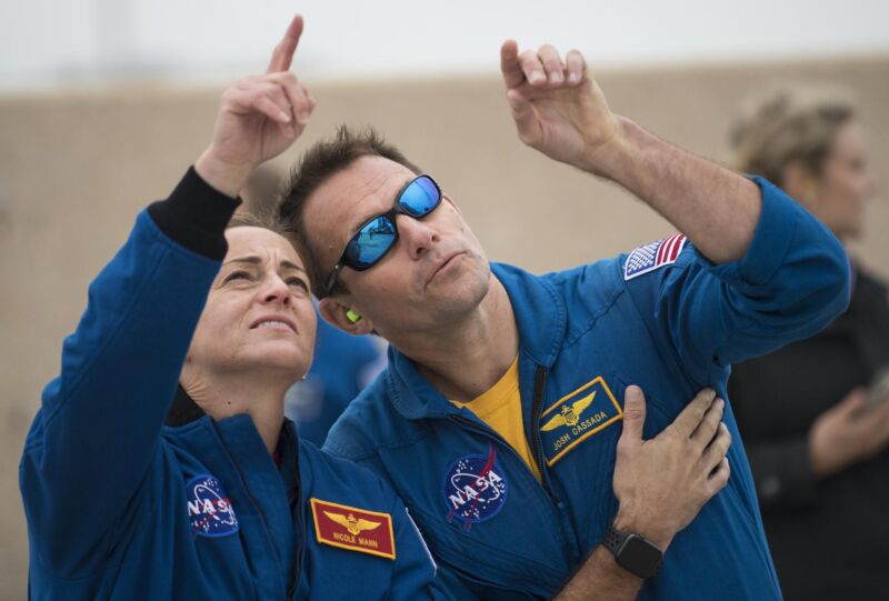 NASA astronauts Nicole Mann and Josh Cassada watch as an Atlas V rocket with Boeing’s CST-100 Starliner spacecraft onboard is rolled to the launch pad ahead of the Orbital Flight Test mission in December 2019.