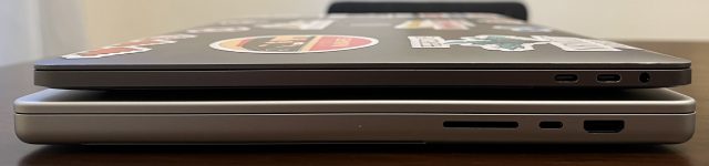 Two laptops on top of each other; the one on the bottom is much thicker