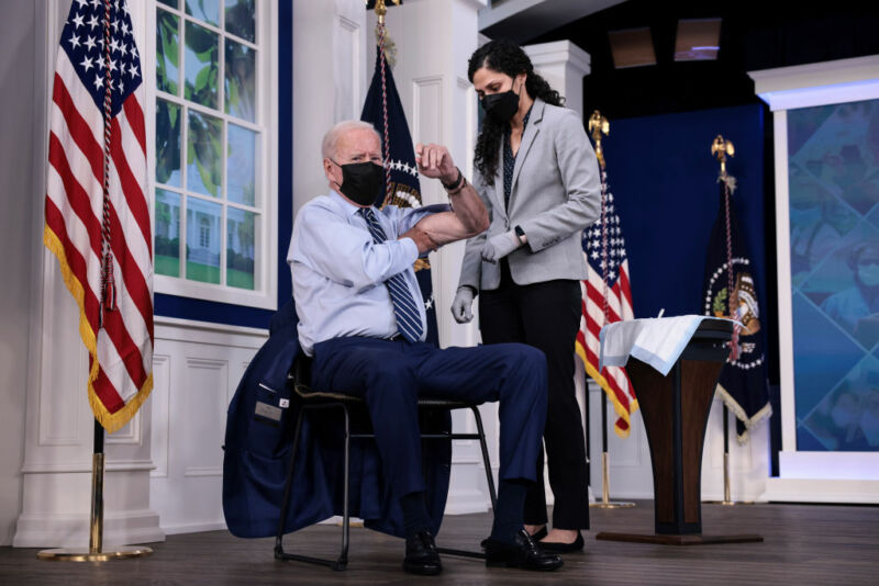 President Joe Biden rolls up his sleeve before receiving a third dose of the Pfizer/BioNTech COVID-19 vaccine