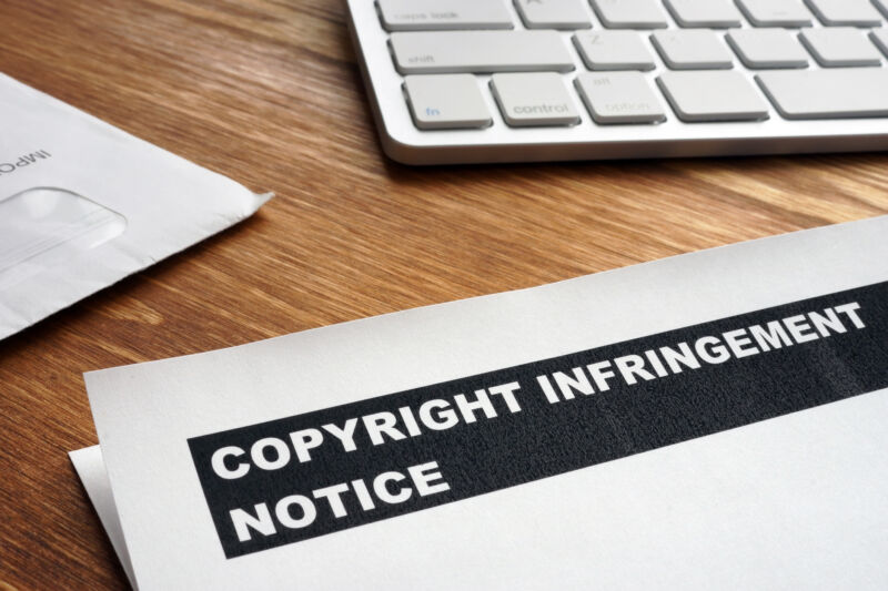 A copyright infringement notice lying on a desk next to a keyboard