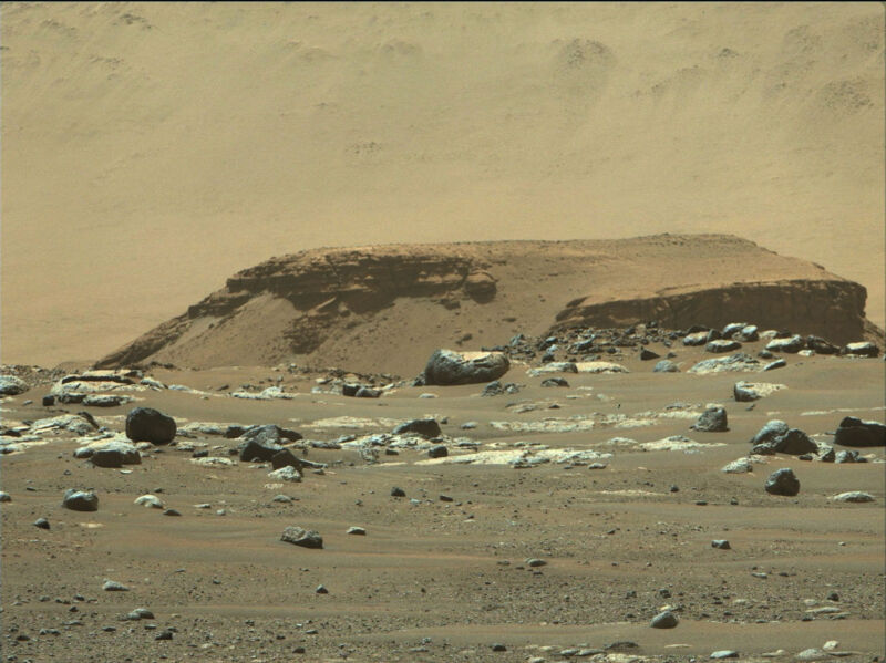 Image of a rock formation tinged with orange.