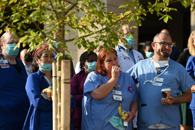 Frontline workers of the Medical Center of Aurora gather in front of the hospital for a COVID-19 memorial in Aurora, Colorado, on July 15, 2021. 