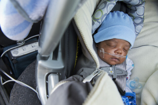 Taylormatthias Wilson-Williams, 2 months, is pictured outside of a water distribution area at the St. Mark Baptist Church in Flint, Mich., on February 23, 2016. He was born 12 weeks premature, and his mother, Tiantha Williams, believes the complication was related to her home's contaminated drinking water. He must use a heart monitor and breathing machine.