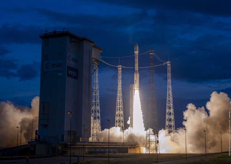 Fire and smoke light up the night sky as a rocket lifts off.