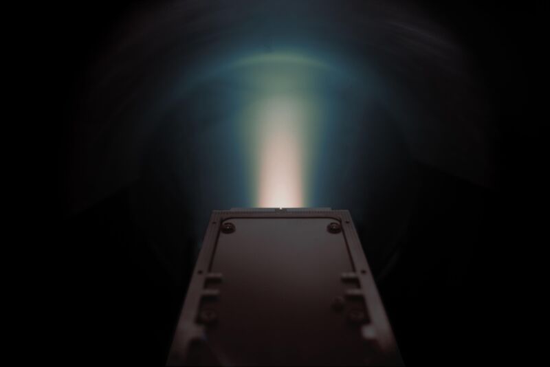 Image of a jet of glowing material emerging from a metal box.